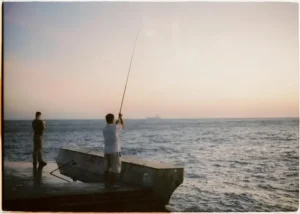 Een man die aan het vliegvissen is in Denemarken, vanaf een pier.