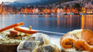 mensen die kabeljauw aan het eten zijn met op de achtergrond de stad bergen in Noorwegen.