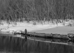 Een man die aan het spinvissen is in Canada in de winter.