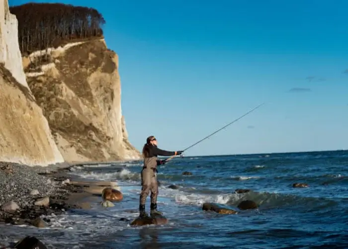Een man die aan het strandvissen is in Denemarken.