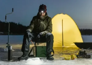 Een man die aan het wintervissen is in Canada.